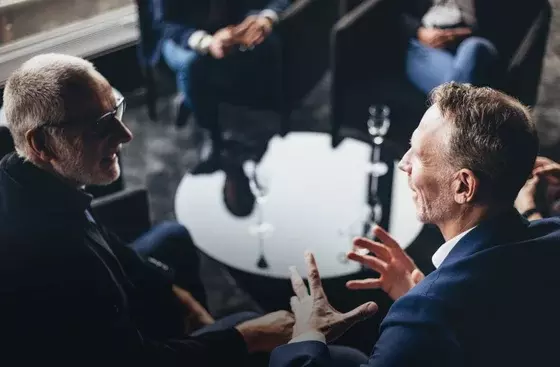 two executives talking over drink table