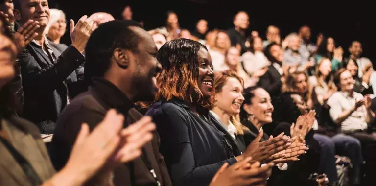 Audience in auditorium clapping