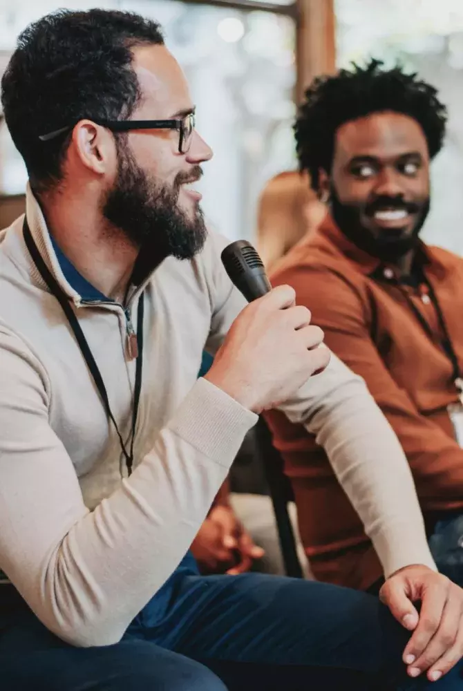 Three conference attendees visiting, one holding microphone