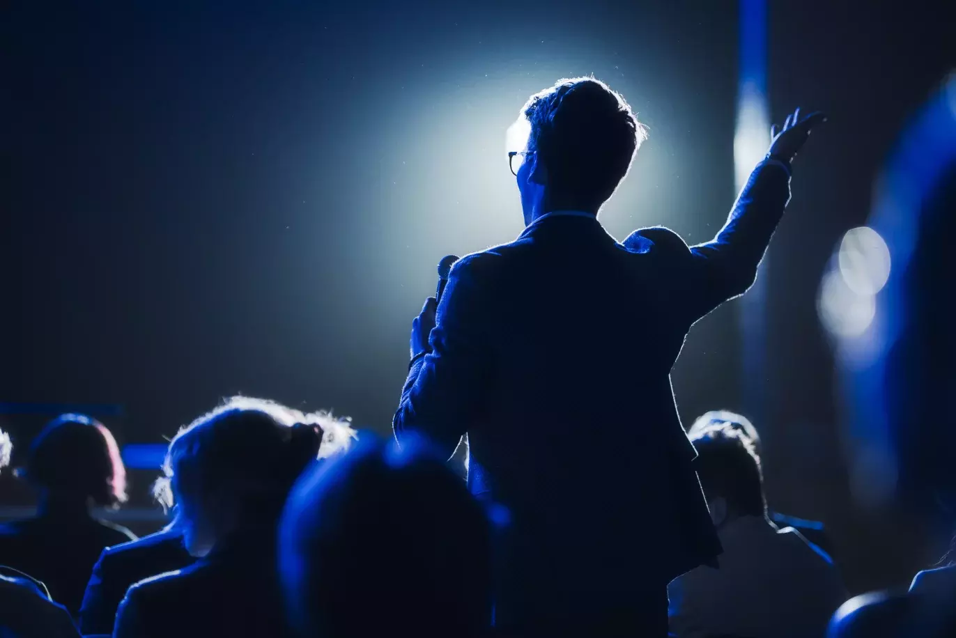 back of person holding microphone at a conference